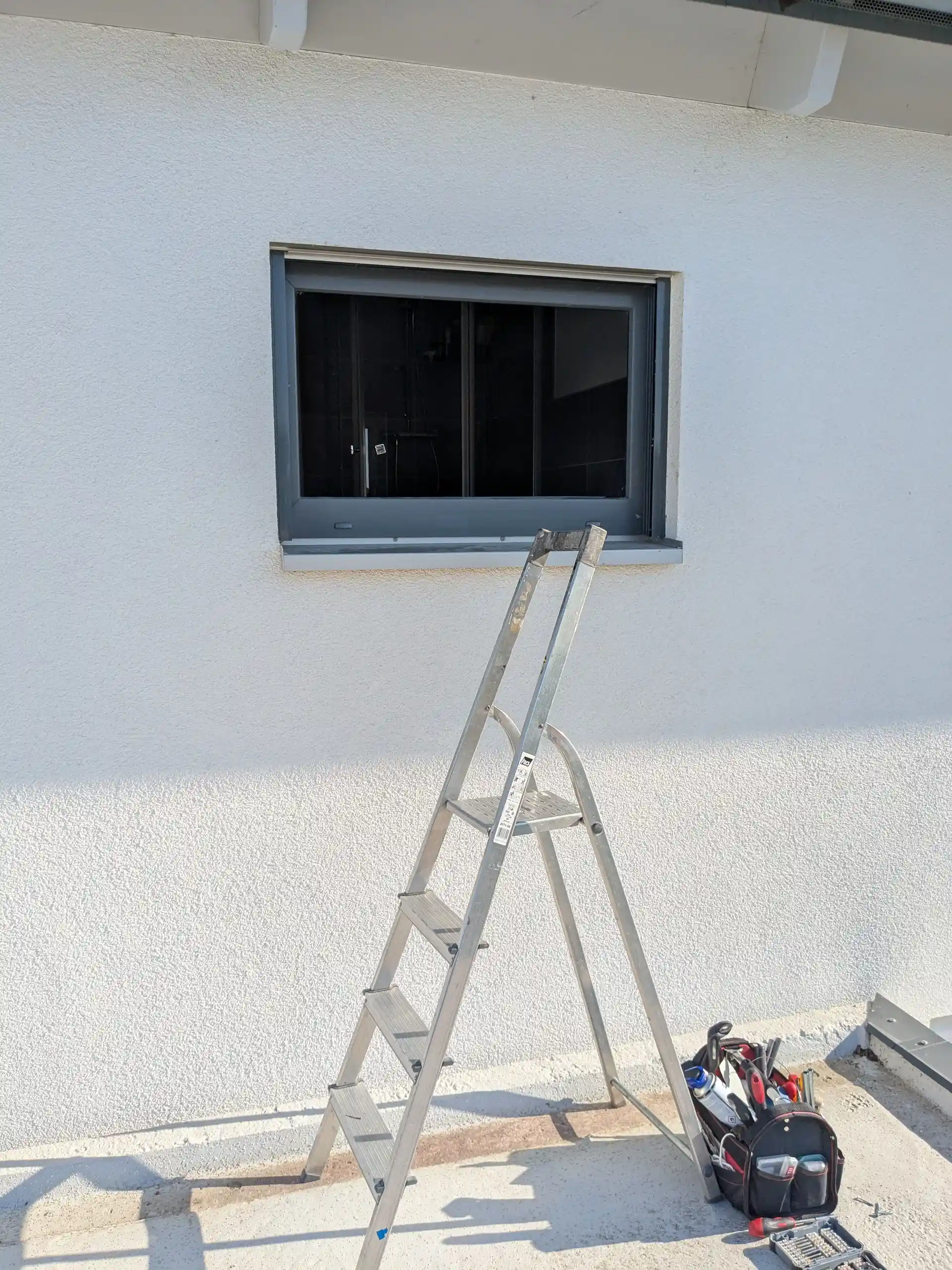 Erdgeschossfenster mit Leiter und Werkzeug als Beispiel für Arbeiten am Einbruchschutz