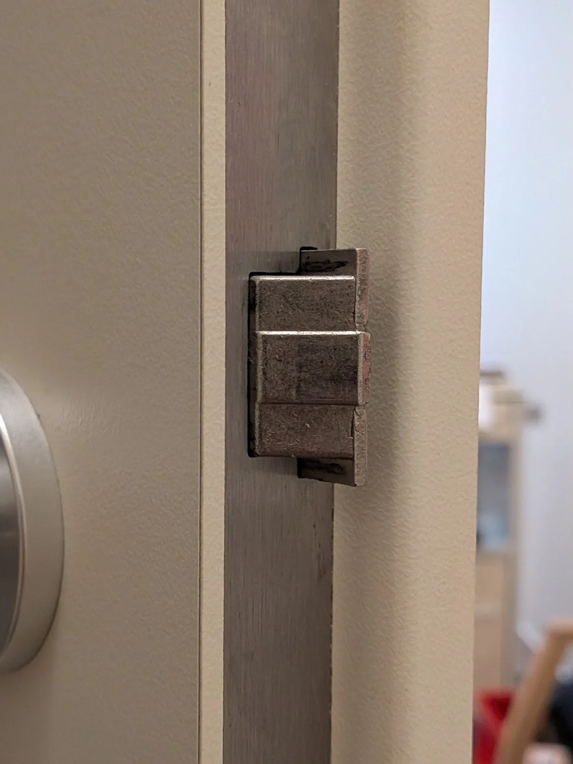 Seitliche Detailaufnahme der Türfalle am Schlossstulp einer geöffneten Tür.