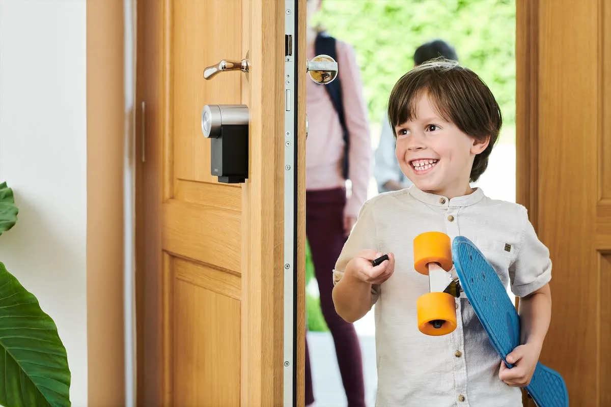 Nuki Smart Lock im Familienalltag: Ein Junge öffnet die Haustür ohne klassischen Schlüssel – smarte Türöffnung und Zutrittskontrolle.