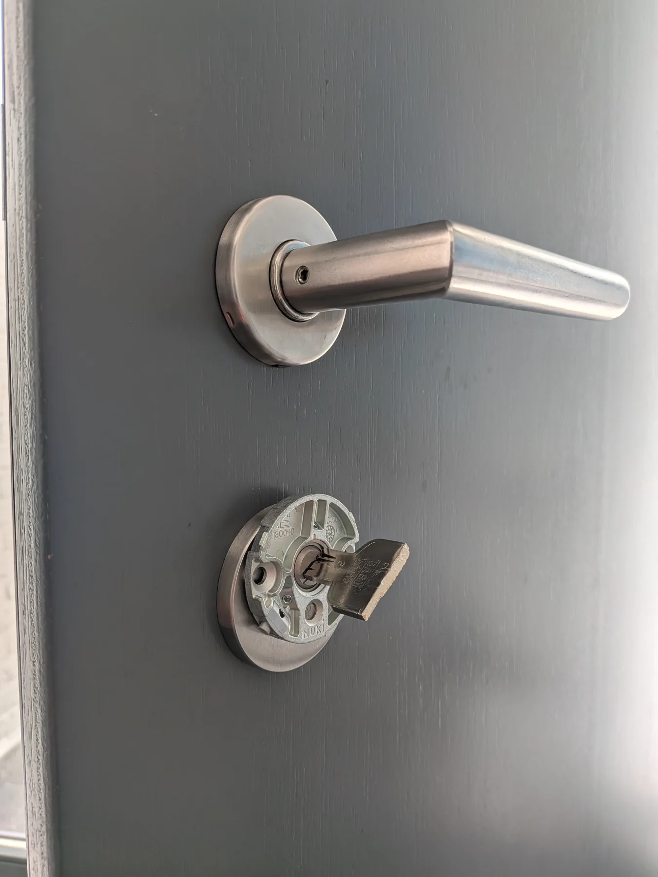 Montageplatte eines Nuki Smart Lock Pro mit eingestecktem Schlüssel an der Innenseite einer Haustür